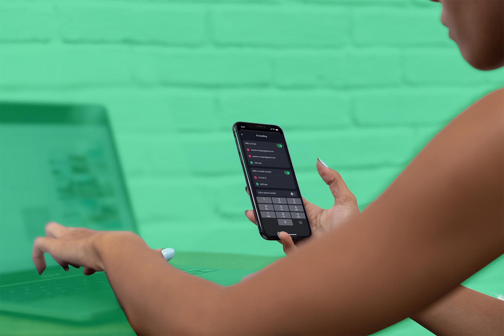 Woman on her laptop holding a phone with the call.com app opened