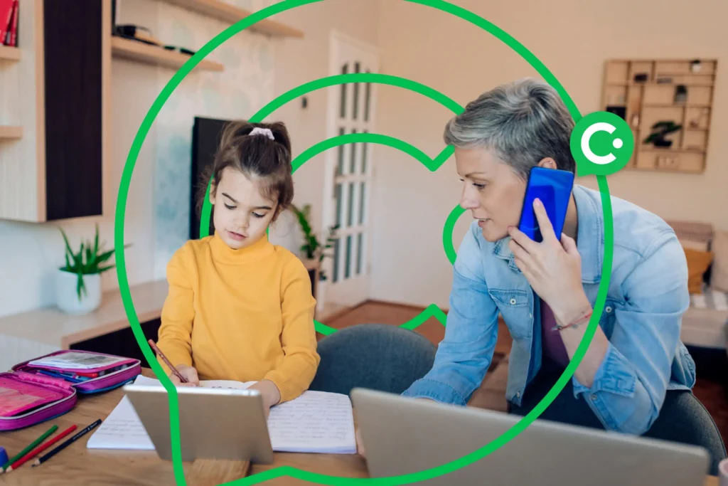A Mother on the phone while helphing his child doing homework