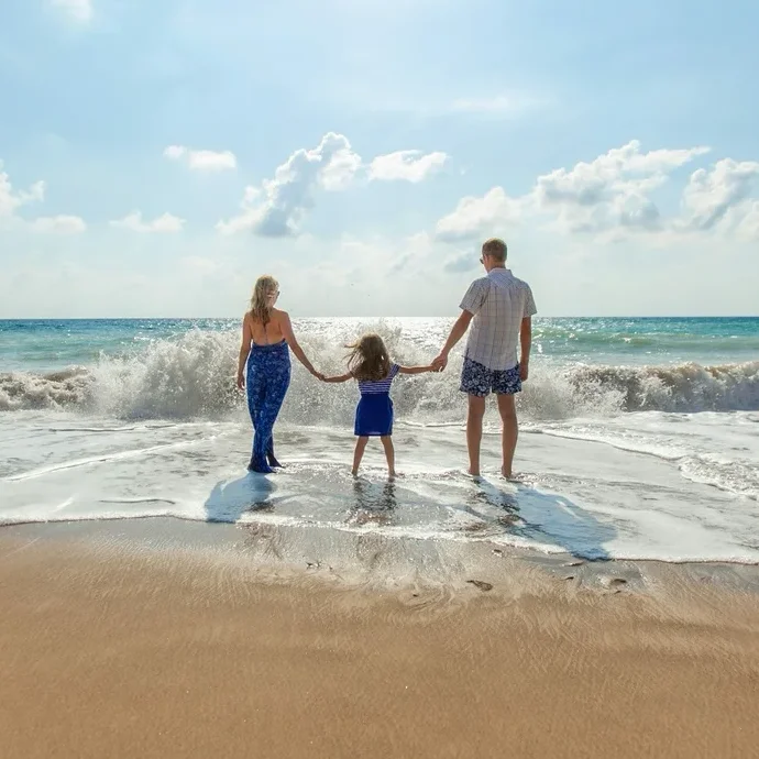 Family holding hands on the beach